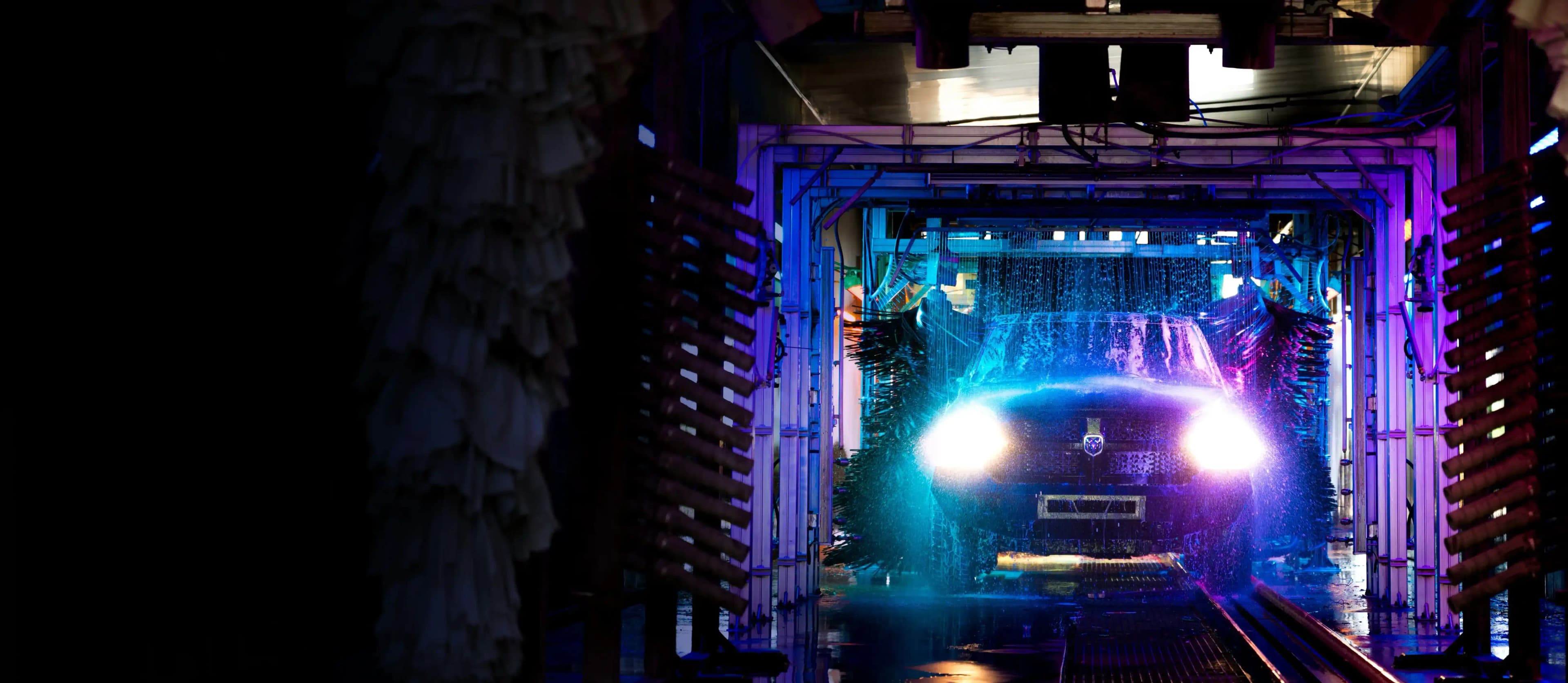 Car in automated car wash with blue and purple lights