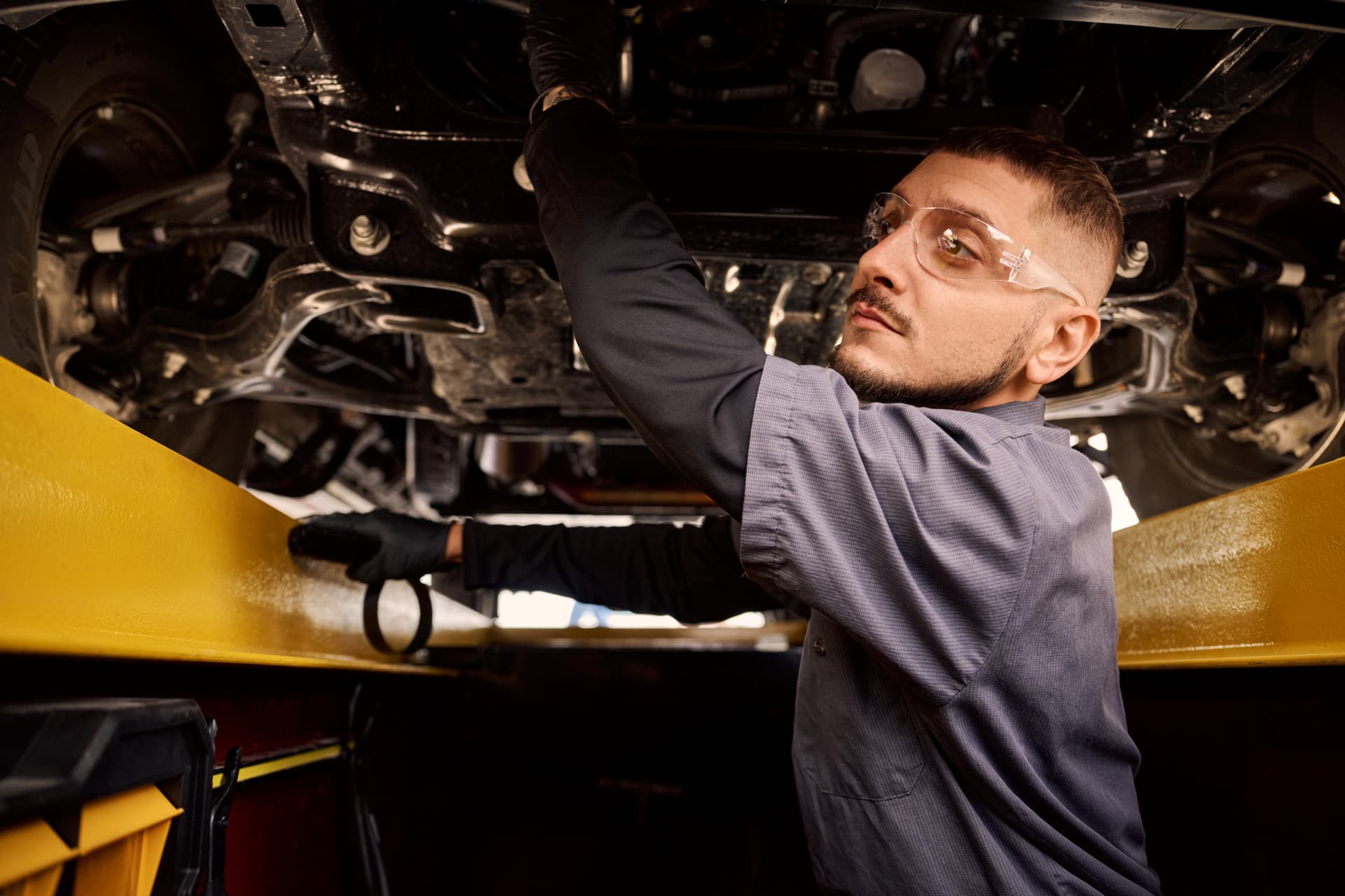 Take 5 Oil Change Technician under a vehicle, changing oil